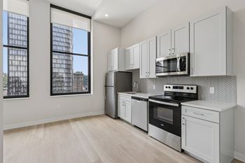 A kitchen with white appliances and cabinets.